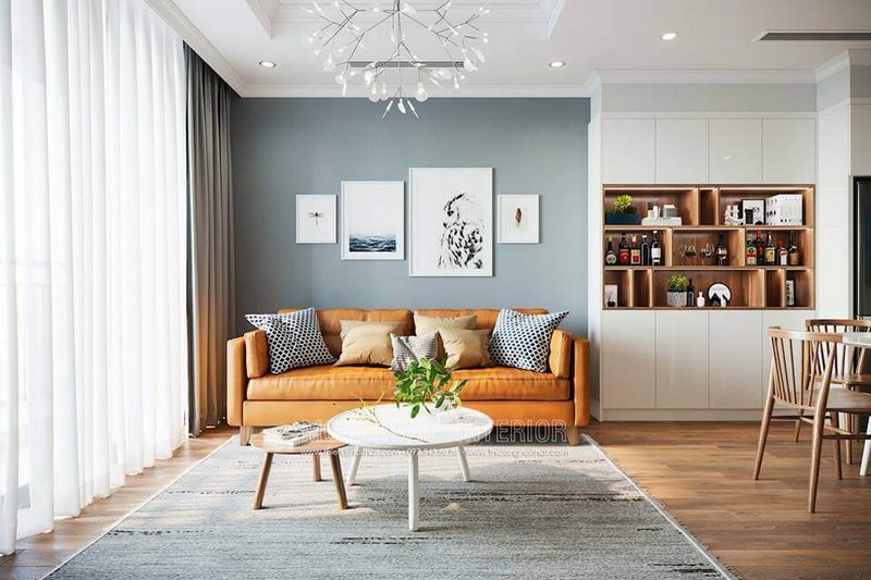Giấy dán tường màu xám xanh kết hợp các bức tranh decor tạo nên sự hiện đại cho phòng khách.